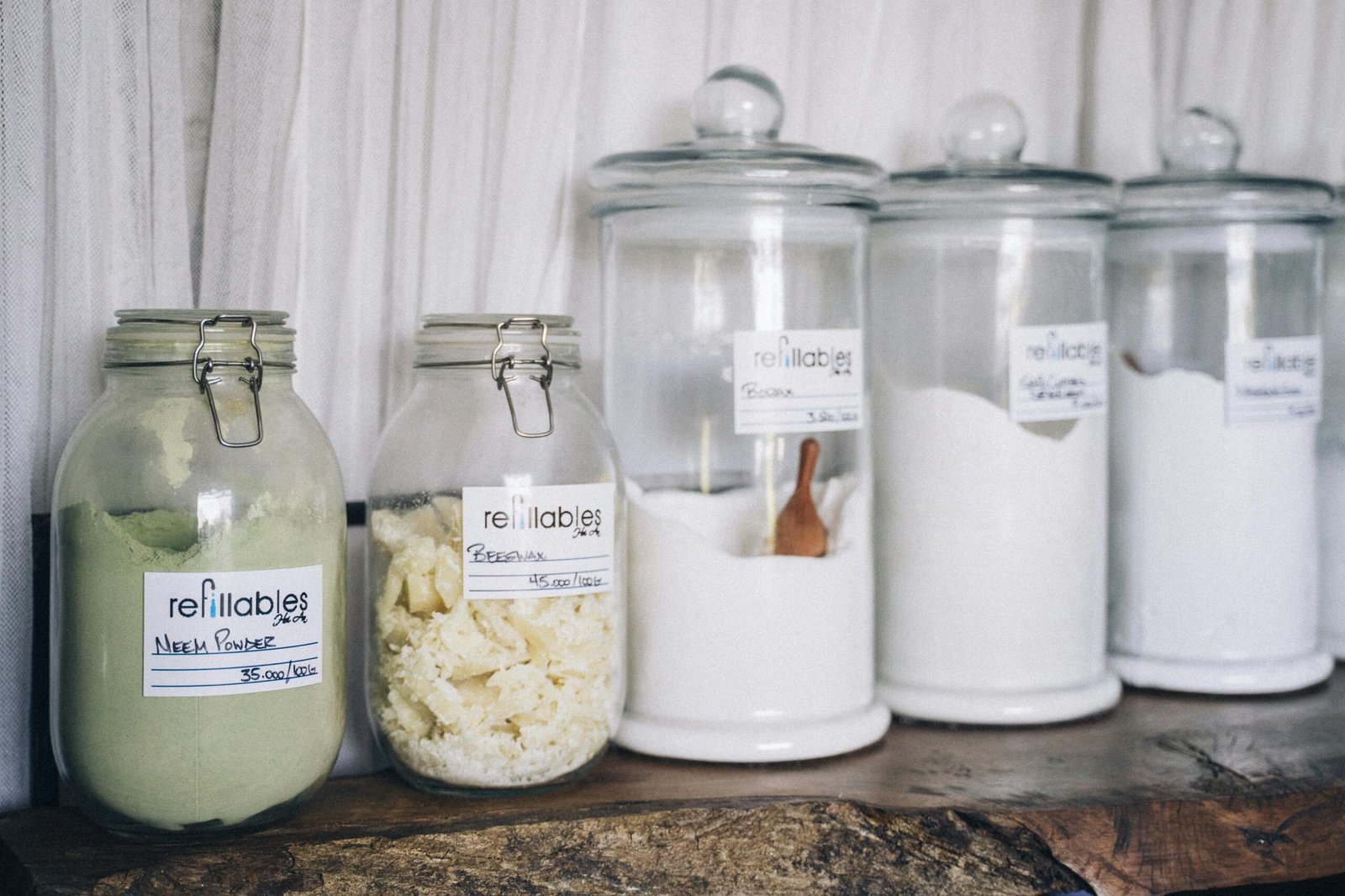 Assorted refillable glass jars containing organic products on display.